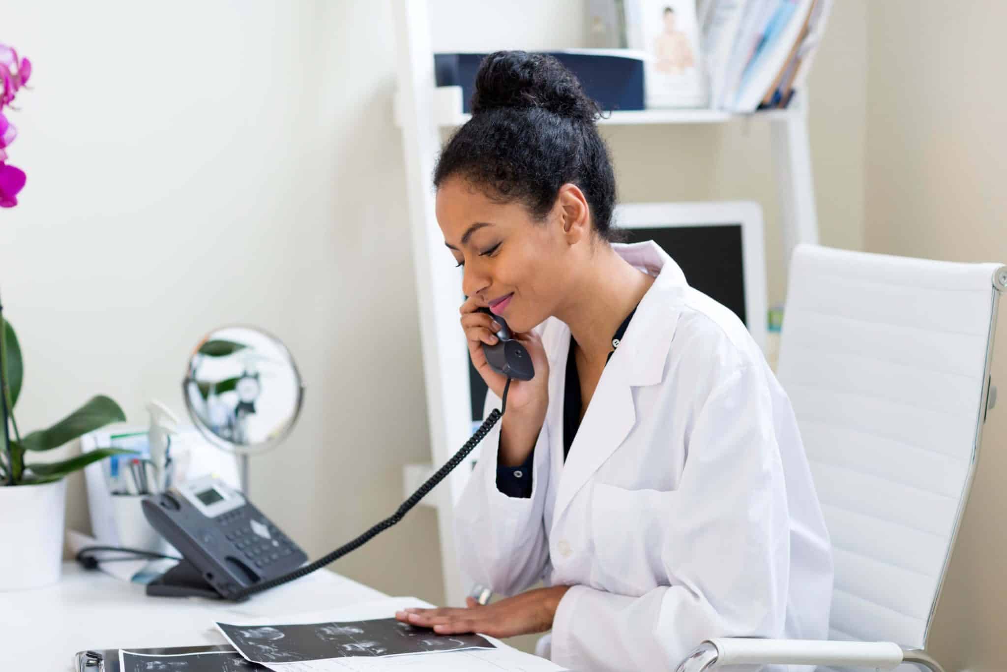 doctor-at-desk-making-telephone-call